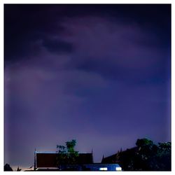 Low angle view of buildings against sky at night