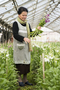 Smiling woman standing in greenhouse