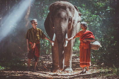 Full length of man standing against trees in forest