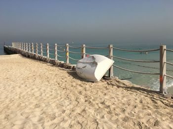 Deck chairs on beach against clear sky