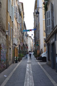 People walking on footpath amidst buildings in city