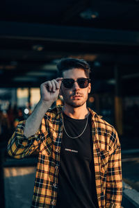 Portrait of young man with sunglasses standing outdoors