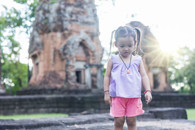 Young woman standing against rock