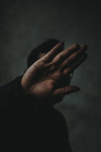 Close-up of man showing hand in darkroom