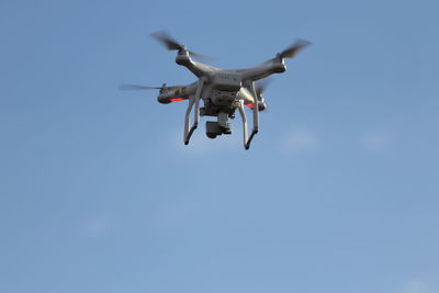 Low angle view of airplane flying against clear blue sky