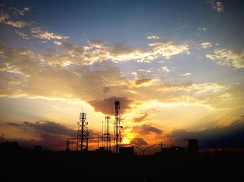 Silhouette of electricity pylon against sky during sunset