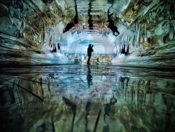 Reflection of silhouette man in water