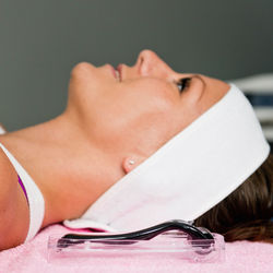 Close-up of woman lying down by cosmetic roller at spa