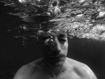 Portrait of young man swimming in pool