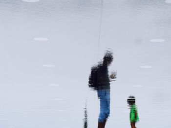 Father and son reflecting in pond