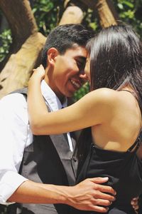 Young smiling couple embracing during sunny day