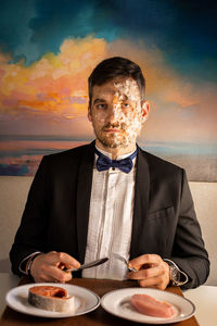 The man with feathers and fish scales on his face.