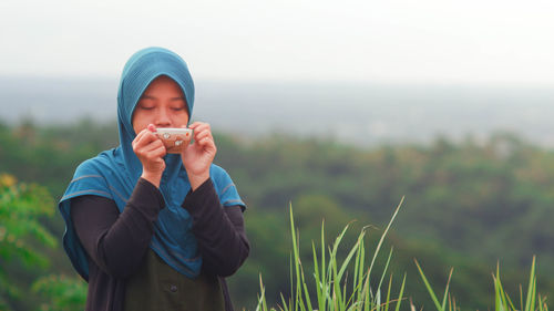 Young man eating food on field