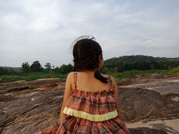 Rear view of woman standing against sky