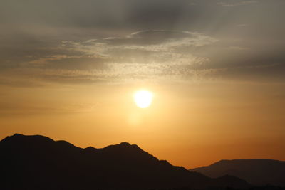 Scenic view of silhouette mountains against sky during sunset