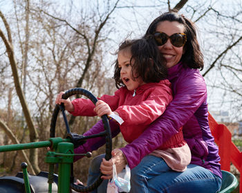 Mom and daughter pretending to drive a tractor 