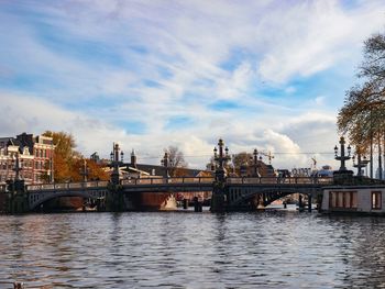 Arch bridge over river against sky in city