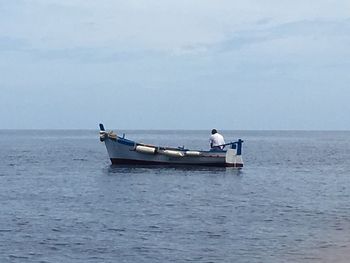 Boat sailing on sea against sky