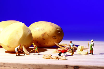 Close-up of fruits on table against blue sky