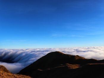 Scenic view of mountains against blue sky