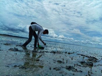 Side view of man on beach against sky