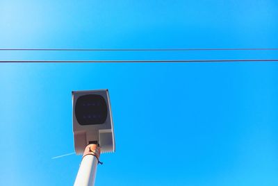 Low angle view of telephone pole against clear blue sky