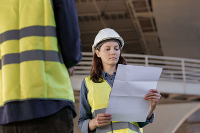 Portrait of young woman holding map