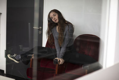 Portrait of young woman sitting on table