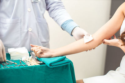 Midsection of doctor vaccinating woman