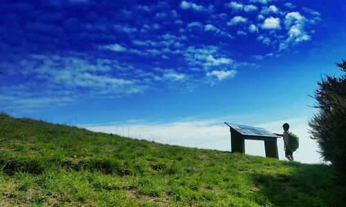 Scenic view of grassy field against cloudy sky
