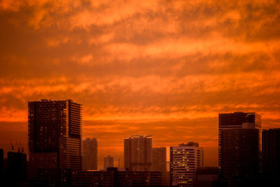 Skyscrapers in city against sky during sunset