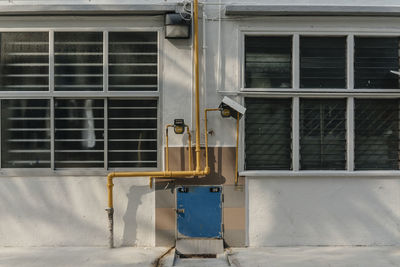 Yellow pipes amidst building windows