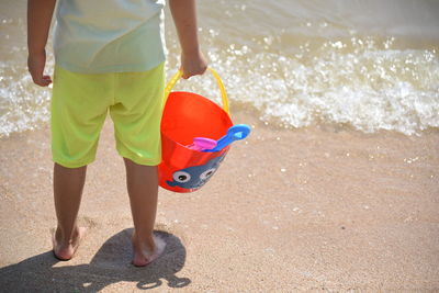 Low section of child standing on beach