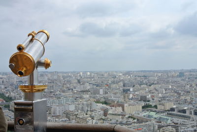 Coin-operated binoculars against cityscape