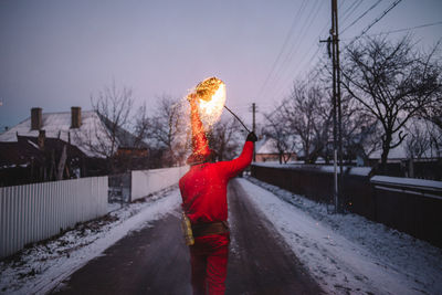 Rear view of man standing on snow covered landscape