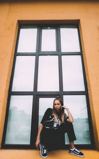 Portrait of woman sitting in window