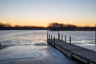 Scenic view of frozen lake against sky during sunset