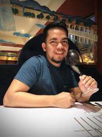 Portrait of smiling young man sitting at restaurant table