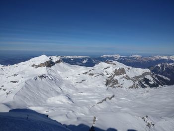 Scenic view of snowcapped mountains against clear blue sky