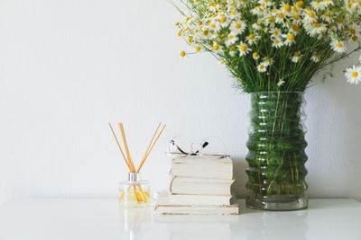 Incense sticks for the home. book, incense sticks and vase with chamomile flowers