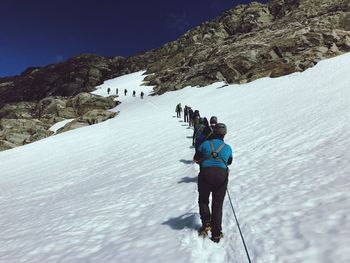 Rear view of hikers on snow covered mountain
