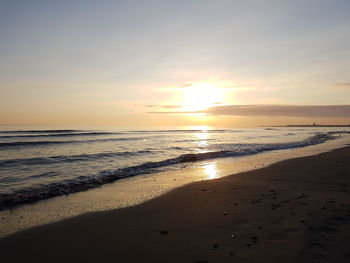 Scenic view of beach against sky during sunset