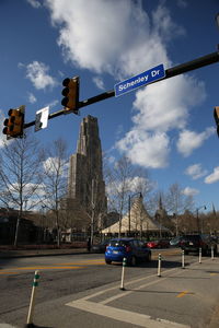 View of road signal against cloudy sky