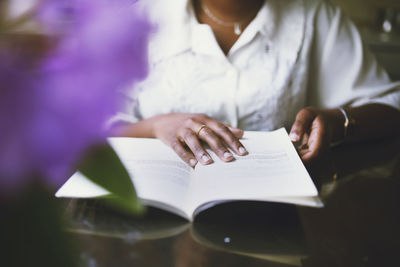 Midsection of woman reading book