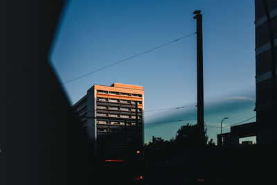 Silhouette buildings against sky at dusk