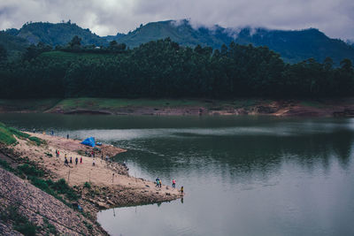 Scenic view of lake by mountain against sky