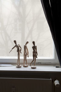 Wooden figurines on window sill