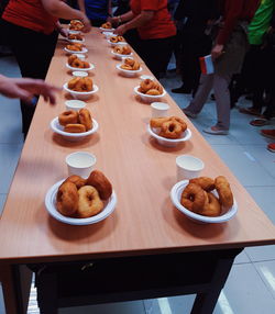 High angle view of people and donuts on table