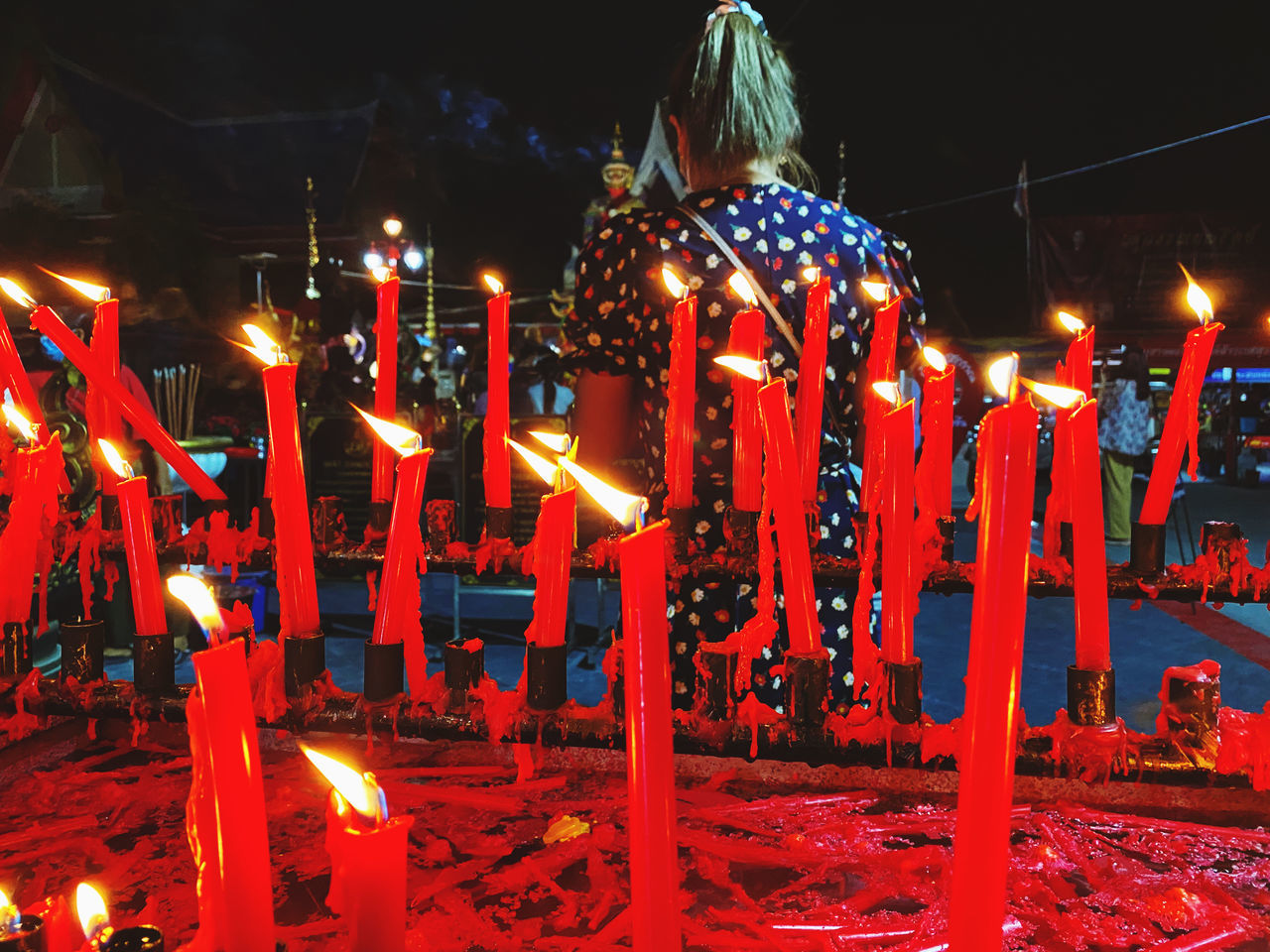 ILLUMINATED CANDLES BURNING AT TEMPLE