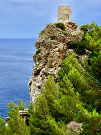 Scenic view of sea by cliff against sky